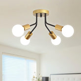 Modern ceiling light fixture with gold and black design in a room setting.